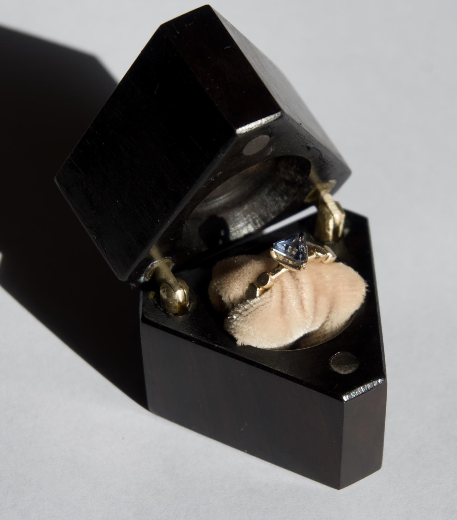 The ring displayed in a handmade wooden presentation box
